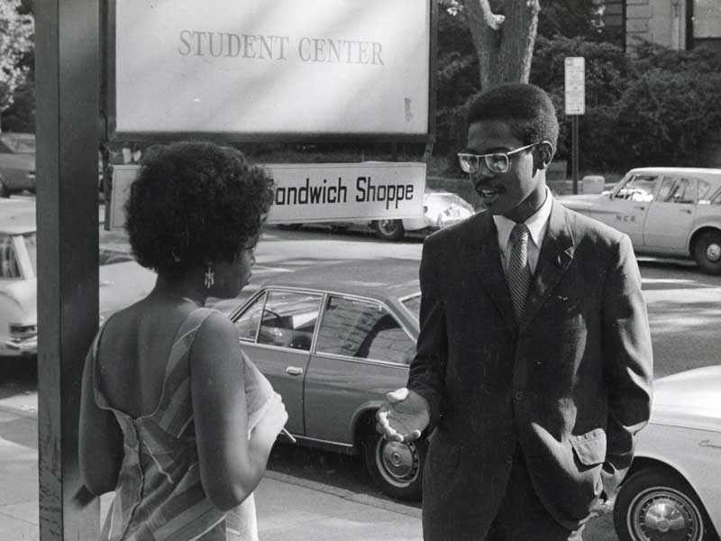 sharon mitchell having a discussion with the director of student affairs in front of the v.c.u. student center in the 1970s