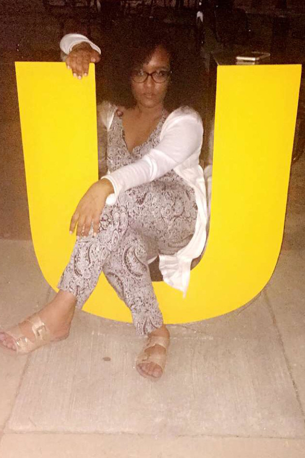 Nardos Iyob sits inside a large letter U