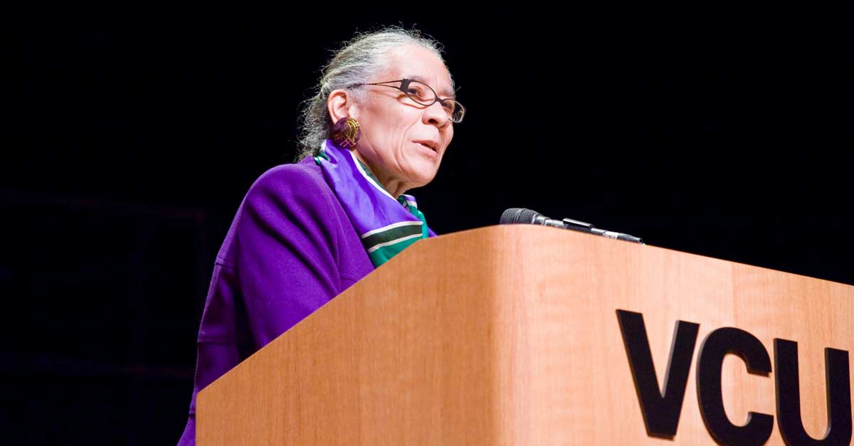 njeri jackson speaking behind a v.c.u. podium