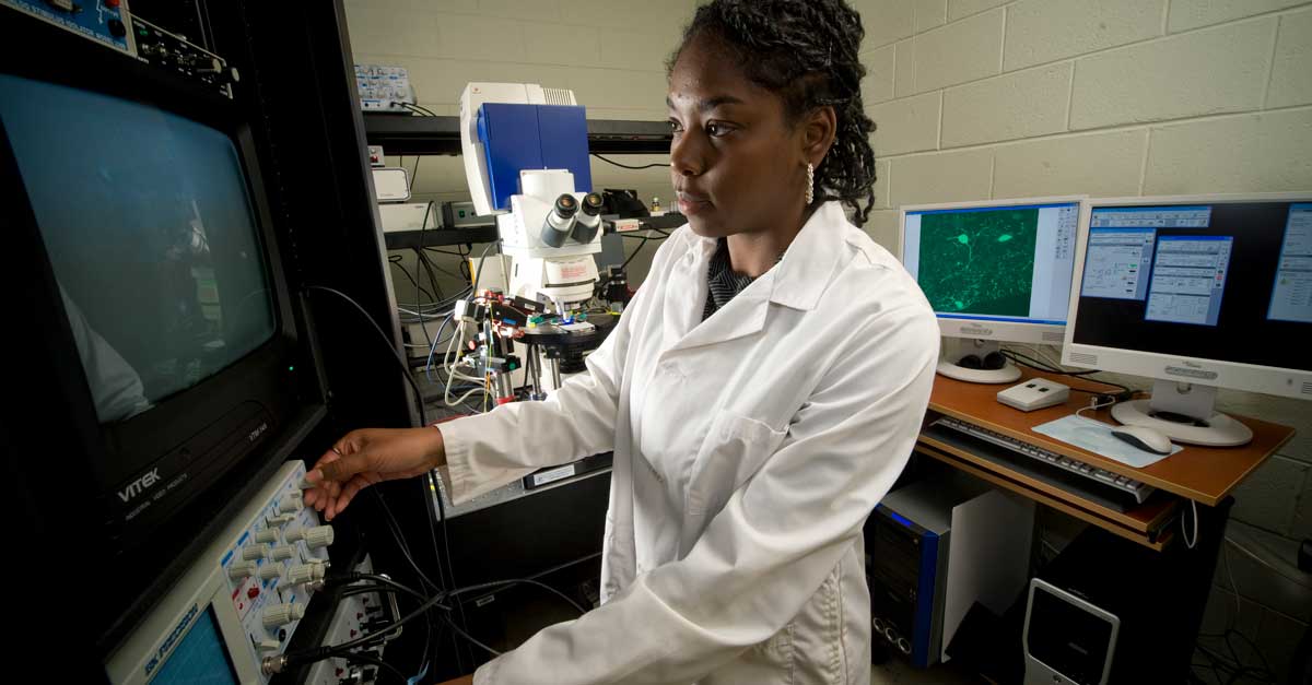 a researcher making adjustments to equipment in a research lab