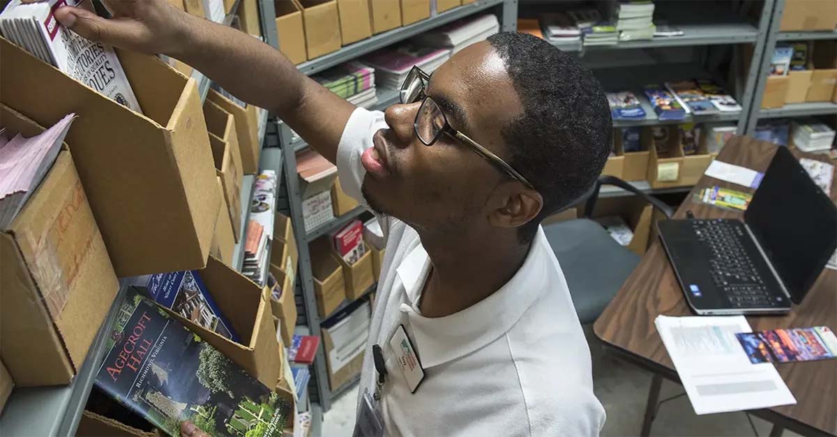 a student searching through files on a shelf